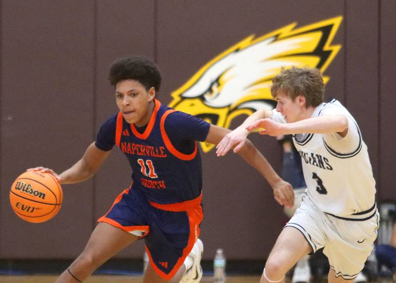 Cary-Grove’s Conner Strike, right, keeps pace with Naperville North’s Antonio Brown in varsity boys basketball Hinkle Holiday Classic action on Monday, Dec. 21, 2025, at Jacobs High School in Algonquin.