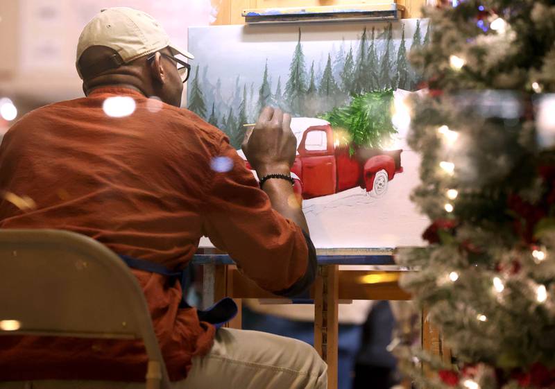 Anthony Nelson works on a holiday painting in the window of KVAL Gallery on State Friday, Nov. 22, 2024, during Moonlight Magic in downtown Sycamore.