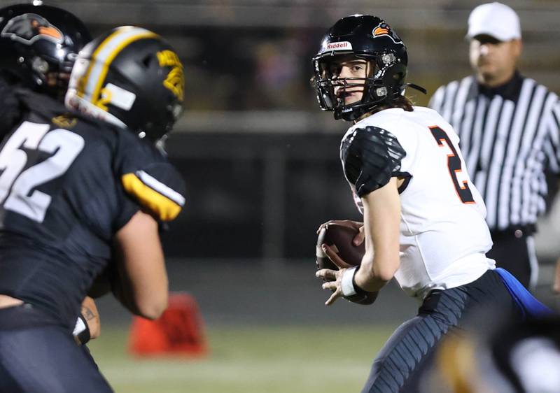 DeKalb's Cole Latimer looks for a receiver as Metea Valley's Brady Jones tries to get pressure during their game Friday, Sept 15, 2023, at Metea Valley High School in Aurora.