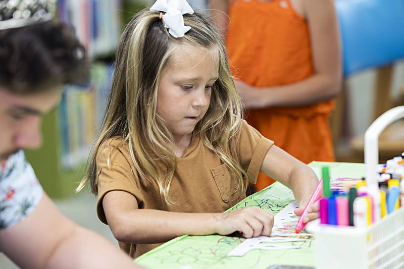 Ellia Pearson, 5, concentrates on her artistic expression Wednesday, June 28, 2023 while working with the Petunia royalty.