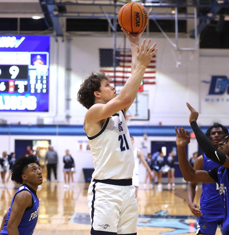 Downers Grove South's Daniel Laurich shoots the ball between two Proviso East defenders during their game Friday, Feb. 14, 2025, at Downers Grove South High School.