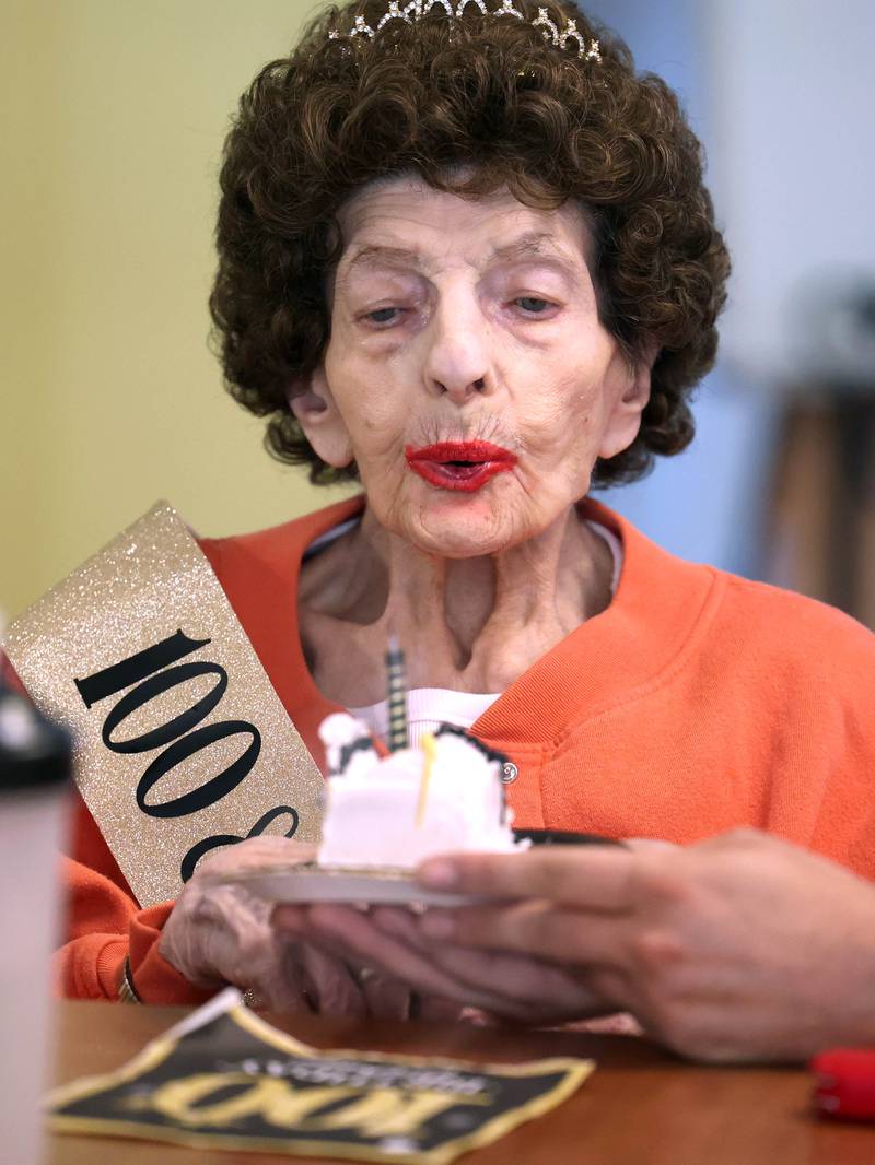 Claire Hubele, a resident at Heritage Woods of DeKalb, blows out a candle on a piece of her birthday cake Wednesday, July 9, 2025, during a party at the facility celebrating her 100th birthday.