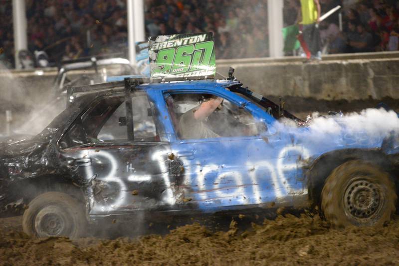 Brenton Dane and his passenger fight off smoke from their demolition car as they compete in the Prostock heat at the Whiteside County Fair's demolition derby on Saturday, Aug. 17, 2024.