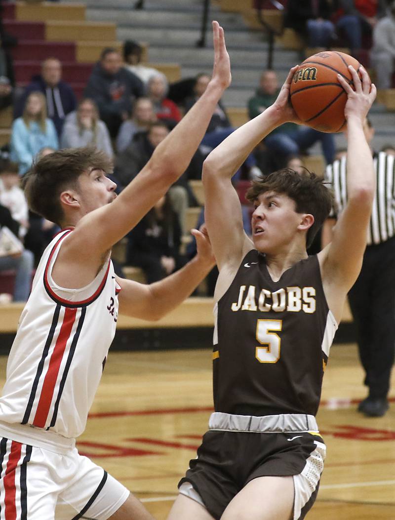 Jacobs' Mark Takasaki tries to shoot the ball over Huntley's Ian Ravagnie during a Fox Valley Conference boys basketball game Tuesday, Jan. 24, 2023, at Huntley High School.