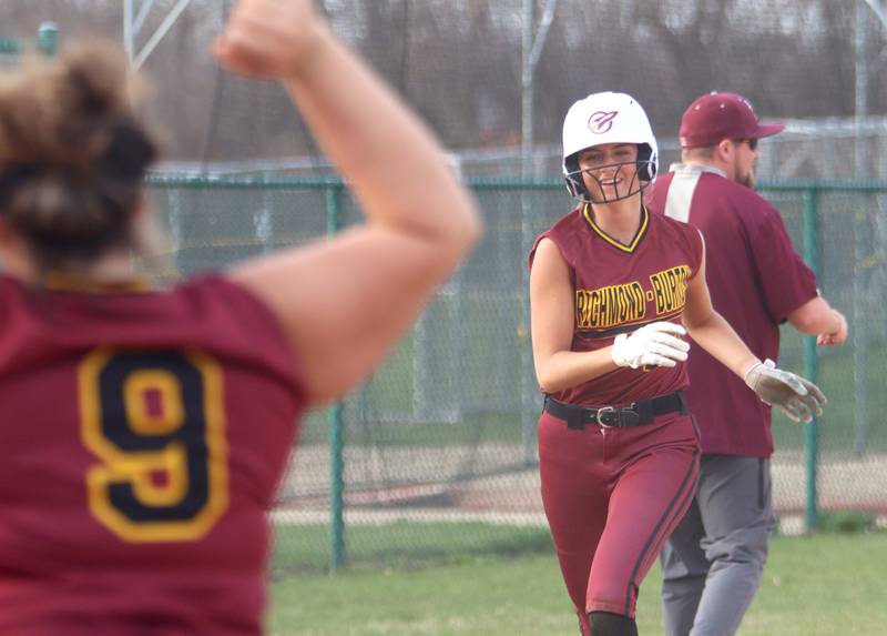 Richmond-Burton’s Mia Spohr, right, heads home on a home run in varsity softball at Marengo Tuesday.