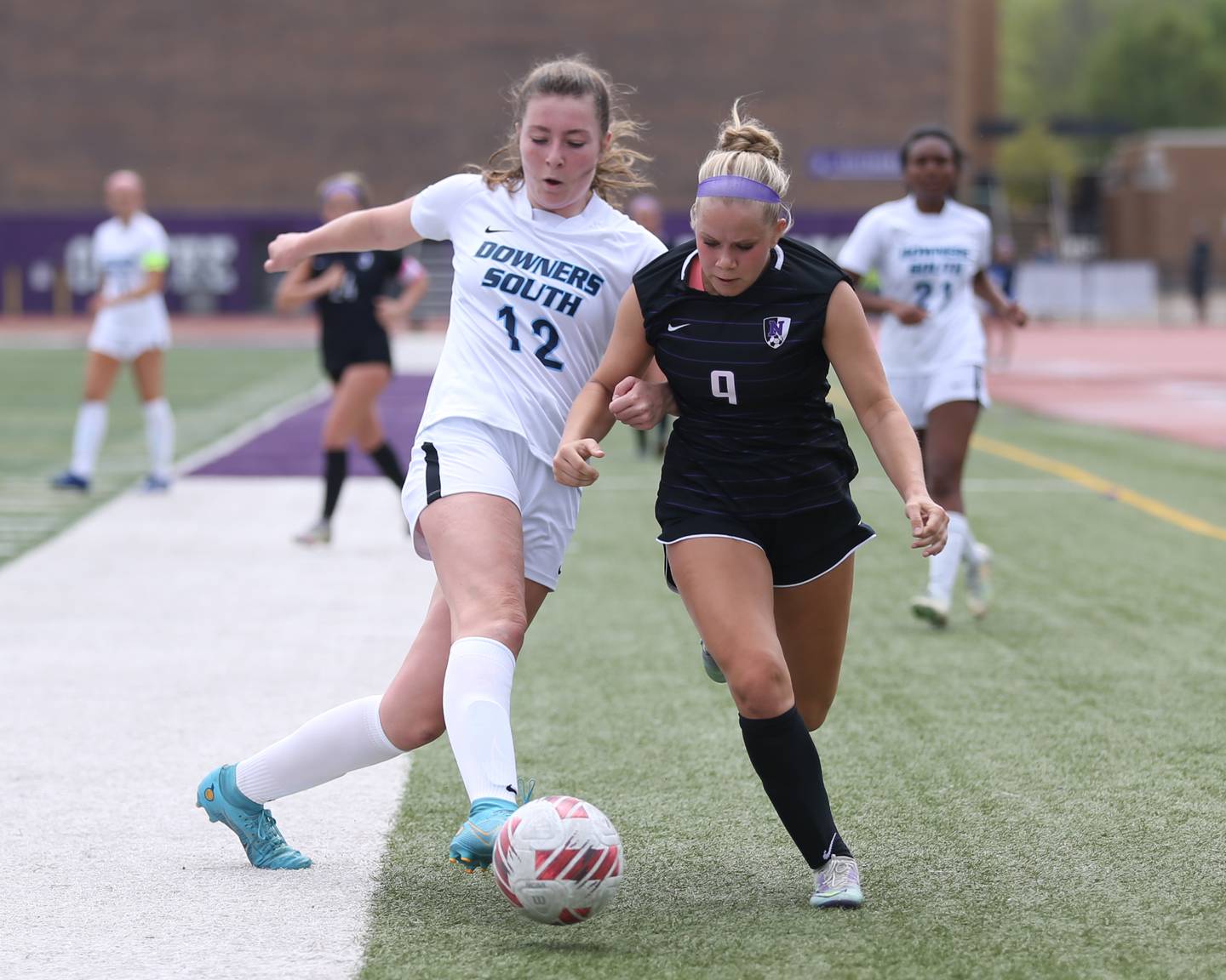 Downers Grove South's Ashley Molinari (12) defends against Downers Grove North's Kate Goray (9) during soccer match between Downers Grove North at Downers Grove South.  May 6, 2023.