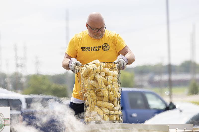Dave Chavira lowers a basket of sweet corn into the cooker Monday, July 22, 2024 for the annual Rotary Club Broil and Boil Lunch. The Sterling Noon and Rock Falls clubs teamed up again to offer the meal of a pork chop, two ears of corn, chips, cookie, and water to their customers.