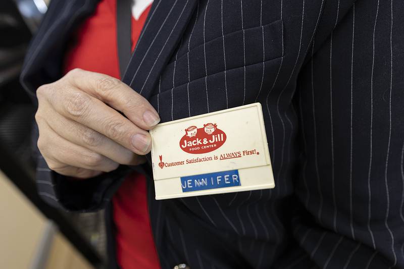 Jennifer LeFever shows off her old name tag Saturday, April 4, 2026, at the store closing celebration at Oliver’s Corner Market in Dixon.