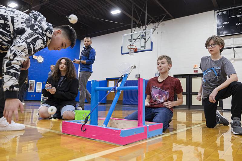 Lonny Briggs (left) gathers up the pumpkins fired from the catapult of his team Logan Stange (middle) and Damon Southard. Each group had three pumpkins to fire as many times in one minute.