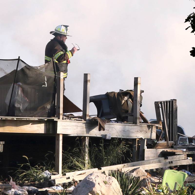 A firefighter overlooks the smoldering rubble that was a house Tuesday, Oct. 17, 2023, after an explosion at the residence on Goble Road in Earlville. Several fire departments responded to the incident at the single-family home that left one person hospitalized.