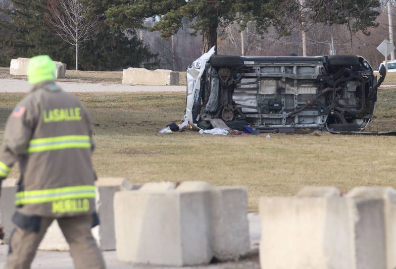 A La Salle firefighter looks at a vehicle rollover scene near the entrance to La Sale Speedway on Monday, Jan. 12, 2026 on U.S. Route 6 in La Salle. The crash happened around 8:30a.m. Crews from Utica and La Salle responded to the scene. OSF Lifeflight helicopter landed in the parking lot of La Salle Speedway to transport one patent.