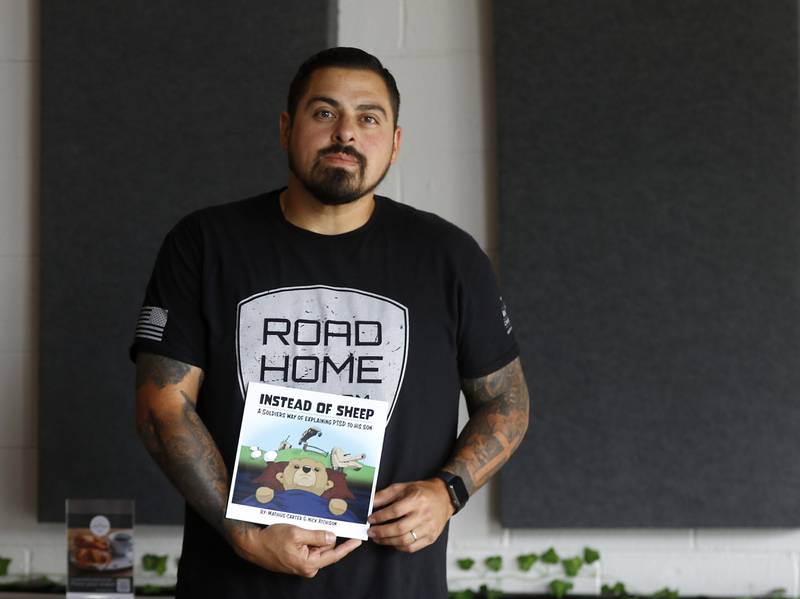 Veteran Mathius Carter, 40, a holds the book that he wrote to explain Post Traumatic Stress Disorder to his 5-year-old son.