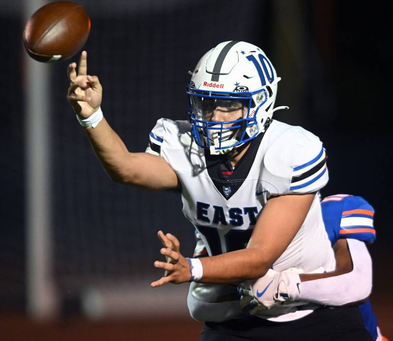 Maine East quarterback Tryfon Giolas tries to get rid of the ball while being pressured during Friday’s football game at Hoffman Estates.