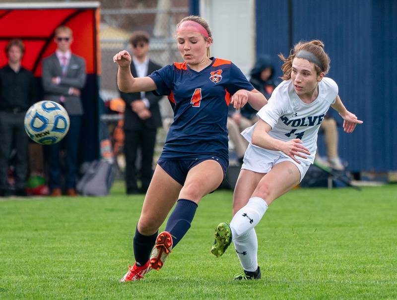 Oswego East's Taylor English (14) shoots the ball against Oswego’s Katelyn Epstein (4) during a soccer match at Oswego High School on Monday, May 2, 2022.