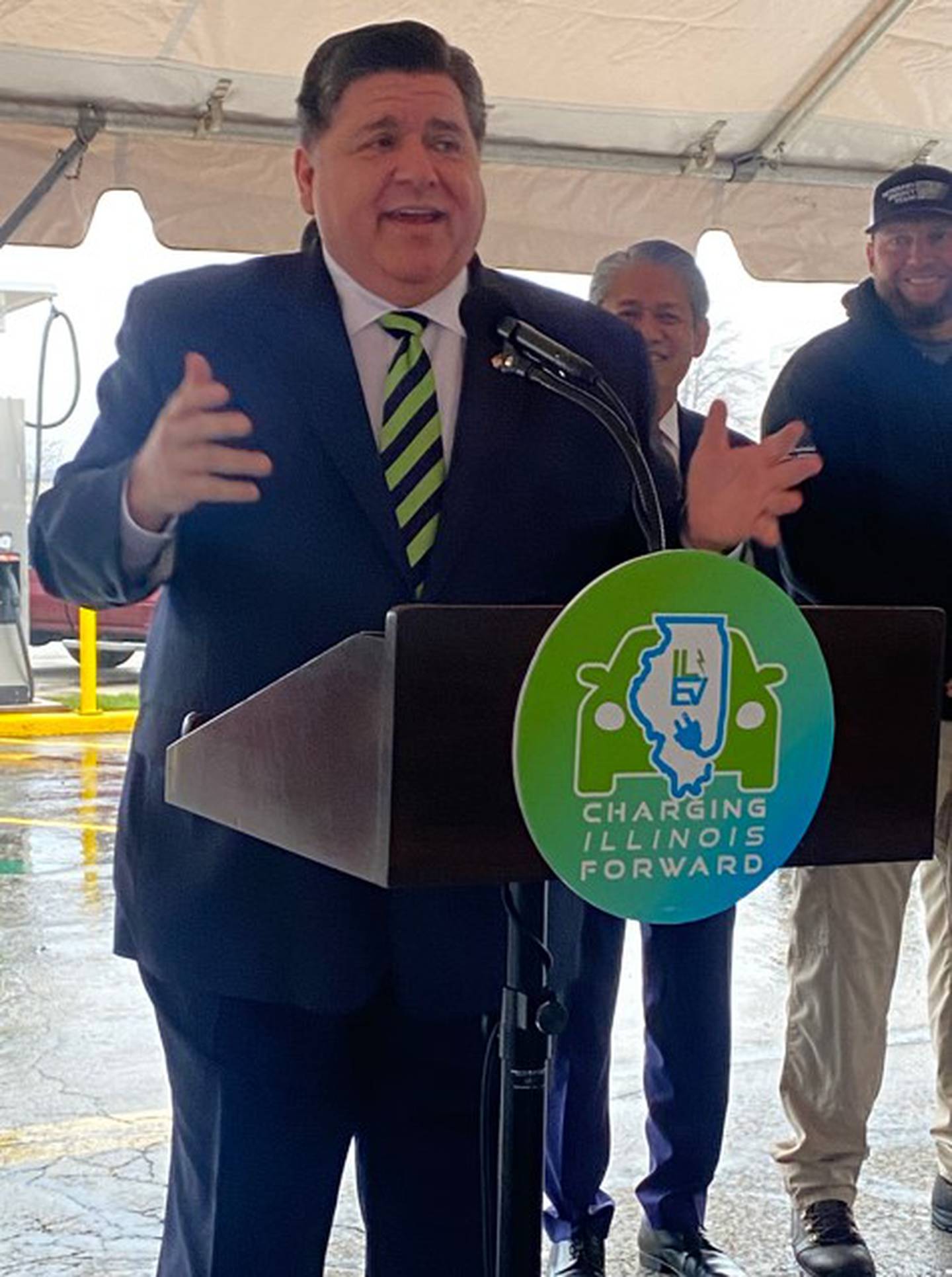 Gov. JB Pritzker, ComEd Ceo Gil Quiniones, and Ed West, owner of Joliet-based Veterans Energy Team, which facilitated the installation of the charging station.