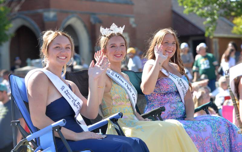2025 Ogle County Fair Queen Ruby Mulvaney (center), Second Runner Up Ali Danekas (left), and First Runner Up Julia Hoefle (right) wave to the crowd as they ride in the Harvest Time Parade during the Autumn on Parade festival on Sunday, Oct. 5, 2025 in Oregon.