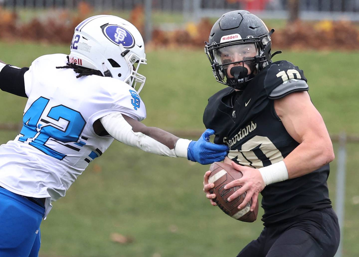 Sycamore's Burke Gautcher tries to escape the pass rush of St. Francis' Tivias Caldwell Saturday, Nov. 16, 2024, during their Class 5A quarterfinal game at Sycamore High School.