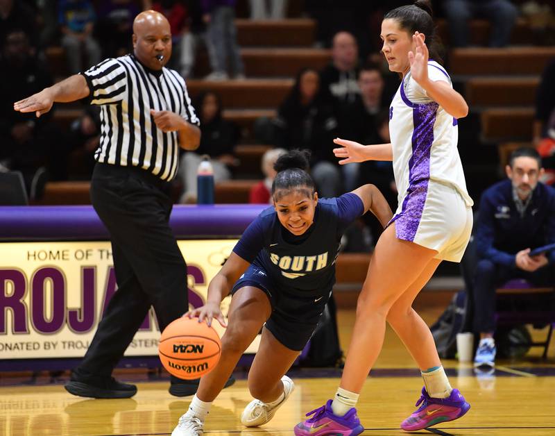 Downers Grove South’s Jakylah Thomas drives past Downers Grove North’s Campbell Thulin during a game on December 20, 2025 at Downers Grove North High School in Downers Grove.
