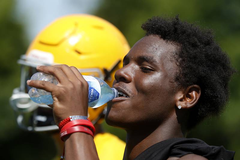 Running back Antonio Brown gets a drink  during football practice Monday, June 20, 2022, at Jacobs High School in Algonquin.