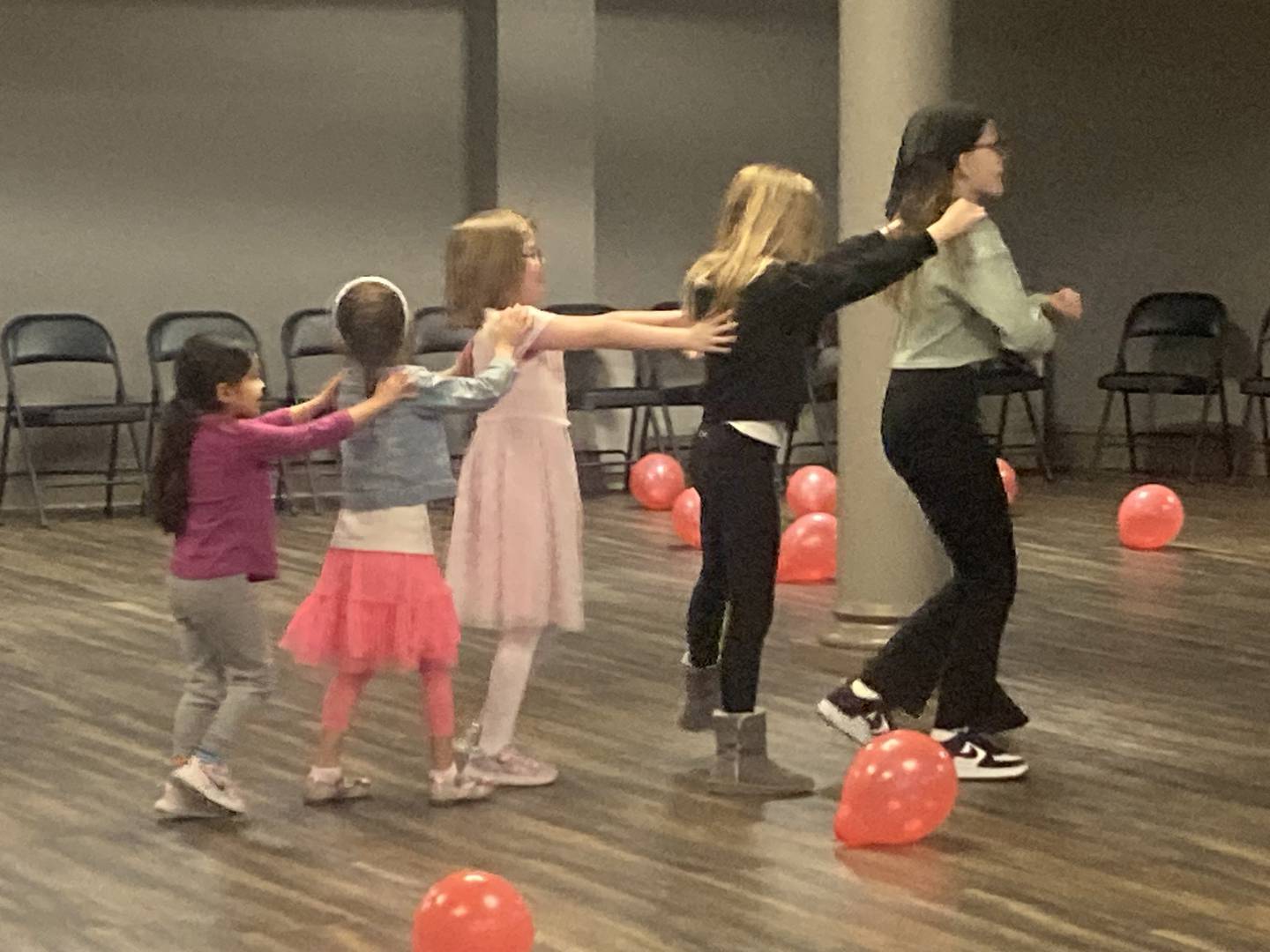 Girls start an impromptu conga line at the Joliet Area Historical Museum's Valentine's Day party on Feb. 8, 2025.