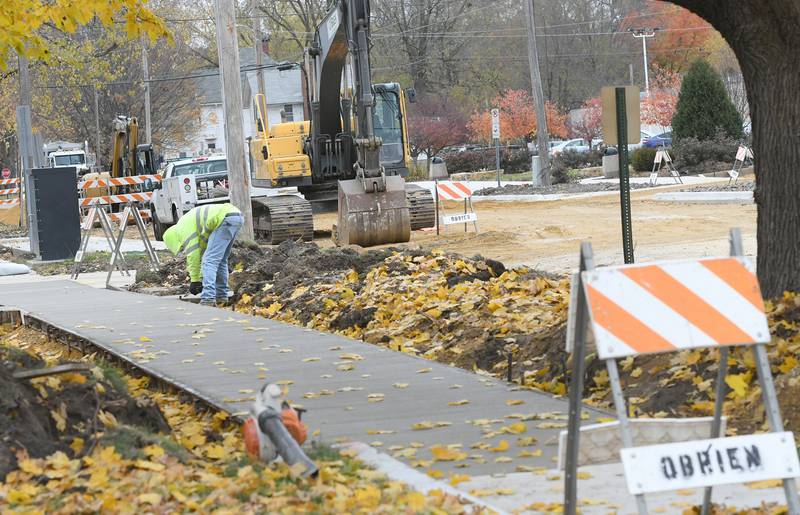 A worker checks on a freshly poured sidewalk in the 100 block of N. Fifth Street in Oregon on Monday. Construction on the street, parking, lot and Franklin Street continues.
