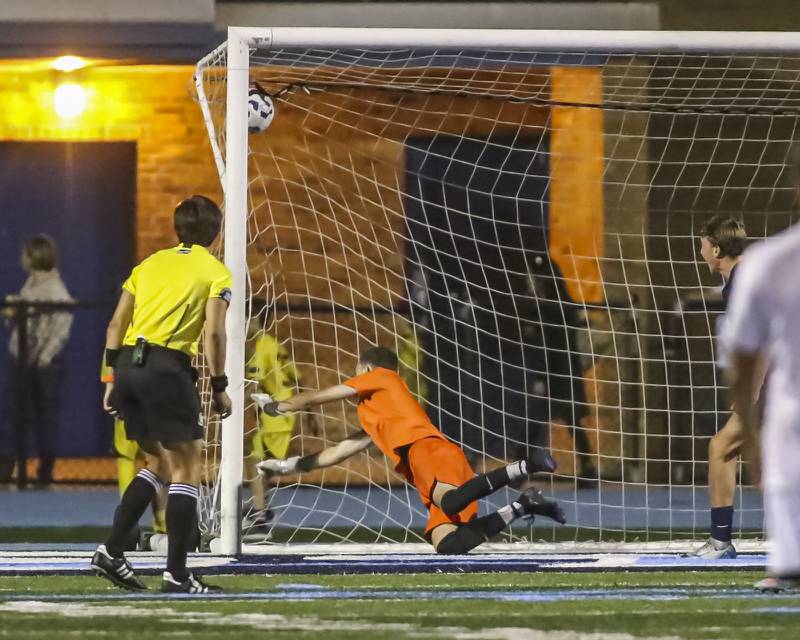 Downers Grove South's Zeke Hall-Taylor (18) kick gets past Downers Grove North's Jack Quinn (1) for a goal during soccer match between Downers Grove North at Downers Grove South. Oct 2, 2025.