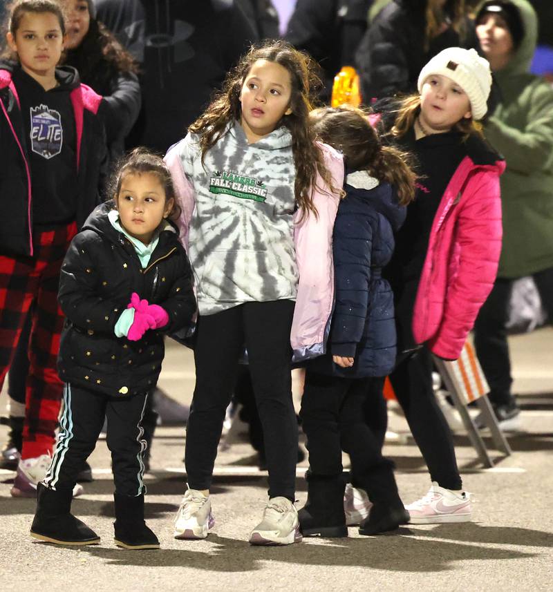 Children peer down the street as the parade approaches Friday, Dec. 2, 2022, during Celebrate the Season hosted by the Genoa Area Chamber of Commerce.