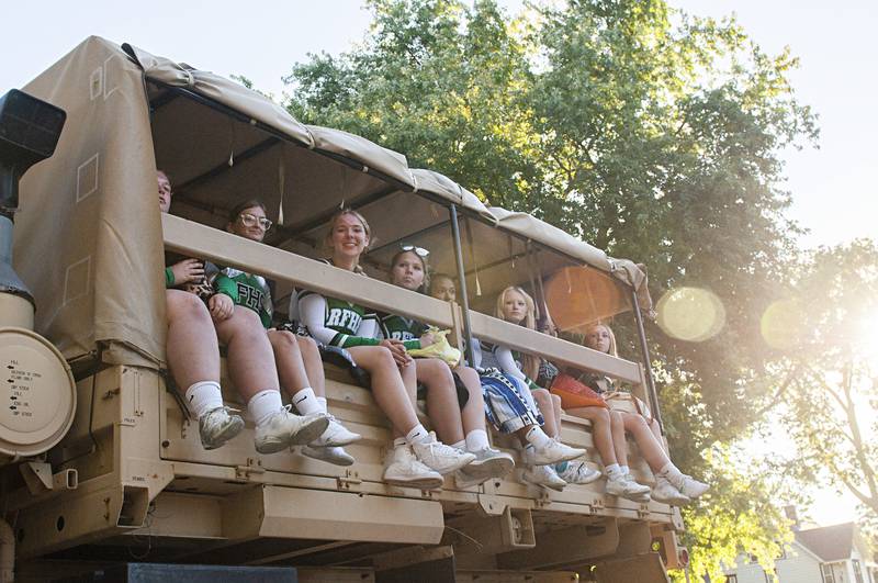 Riding high atop a National Guard vehicle, the Rock Falls cheer squad greets parade goers Thursday, Sept. 22, 2022.