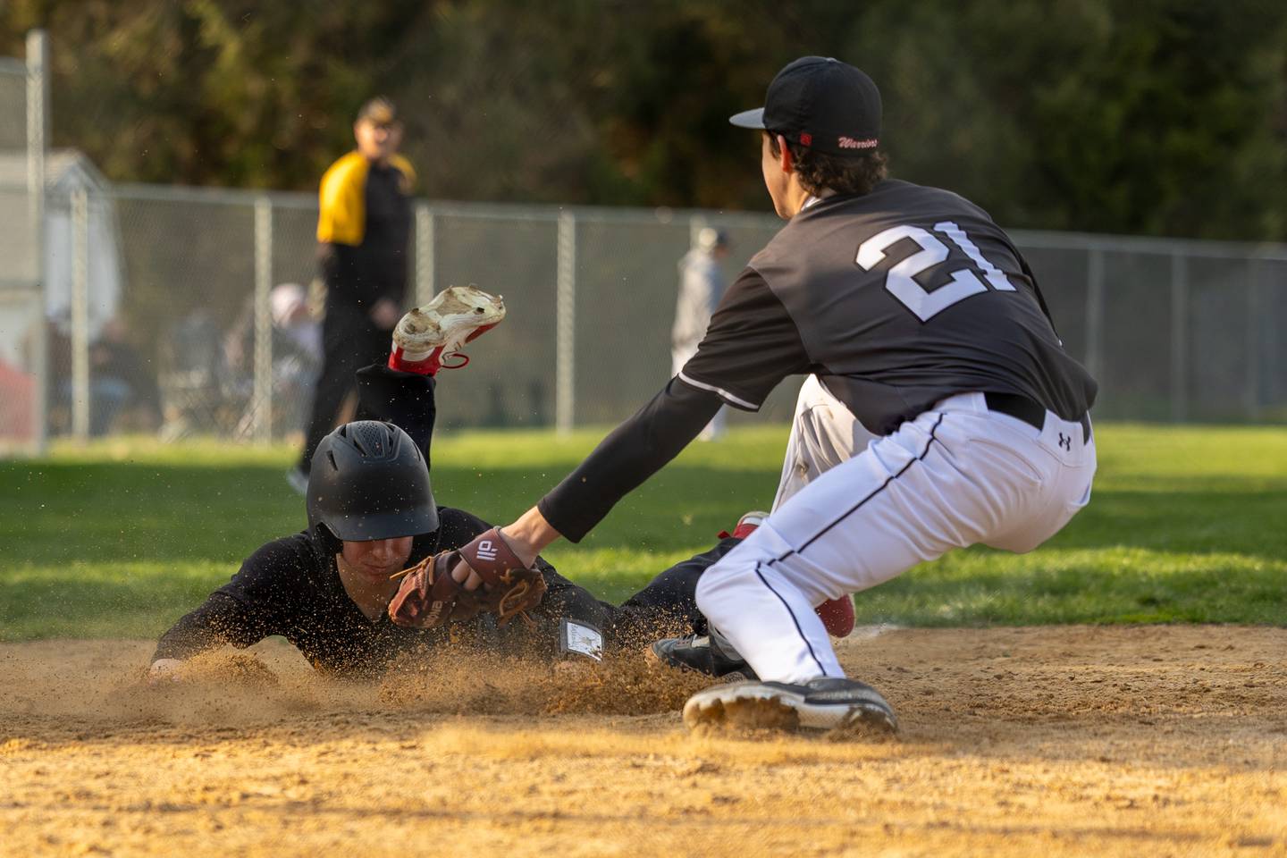 Maddox Poole (6) of Putnam County slides into home plate whilst Reece Pelnarsh (21) of Woodland/Flanagan-Cornell attempts to tag out on Thursday, April 17, 2025 at Woodland High School in Streator.