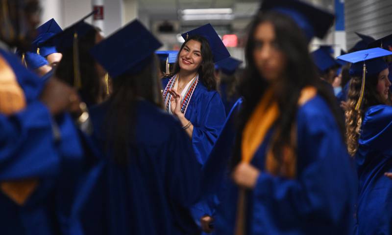 Wheaton North graduate Vera Tax smiles as she waits with friends and fellow seniors before the school's graduation ceremony on Saturday, May 24, 2025 at College of DuPage in Glen Ellyn.