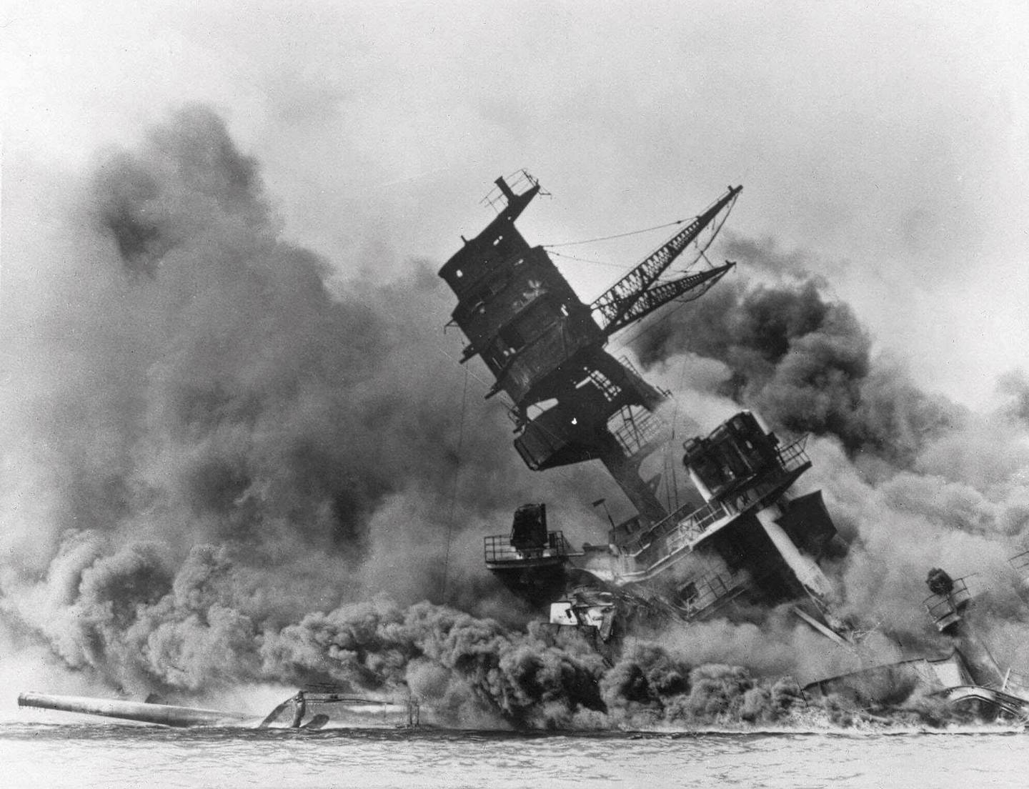 FILE - In this Dec. 7, 1941, file photo, smoke rises from the battleship USS Arizona as it sinks during a Japanese surprise attack on Pearl Harbor, Hawaii. A few dozen survivors of Pearl Harbor are expected to gather Tuesday, Dec. 7, 2021, at the site of the Japanese bombing 80 years ago to remember those killed in the attack that launched the U.S. into World War II.