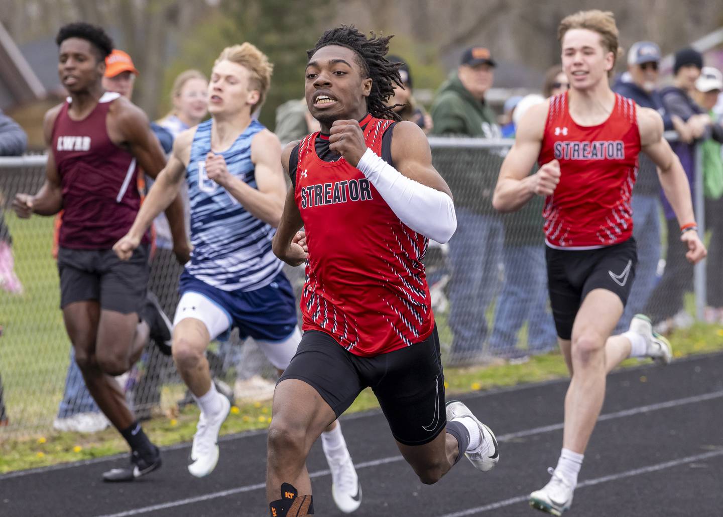 Isaiah Brown of Streator High School leads the pack of runners to the finish line during the boys 200 meter race of the Rollie Morris Invite on April 19, 2025 at Hall High School.