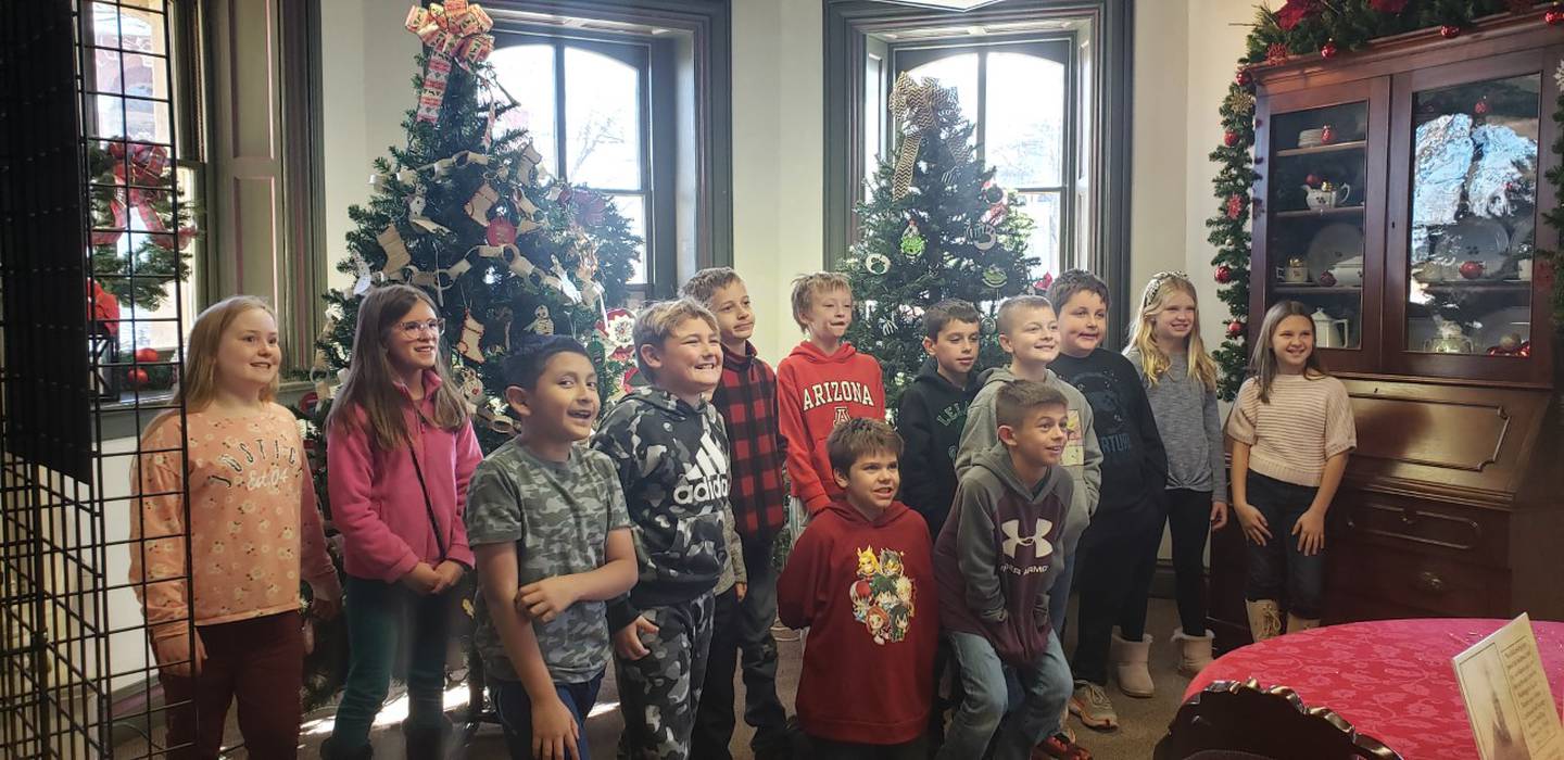 Leland Elementary fourth grade students pose in front of the two Christmas trees they decorated at the Reddick Mansion in Ottawa.
