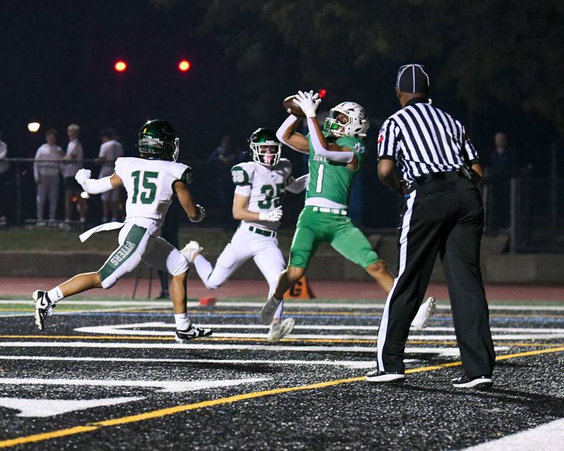 York's Simon Kodosky (1) catches the ball in the endzone for a touchdown during the game on Friday Oct. 17, 2025, while being defended by Glenbard West teammates Bryce Ellens (15) and Finn Sheeley (35) held at York High School.