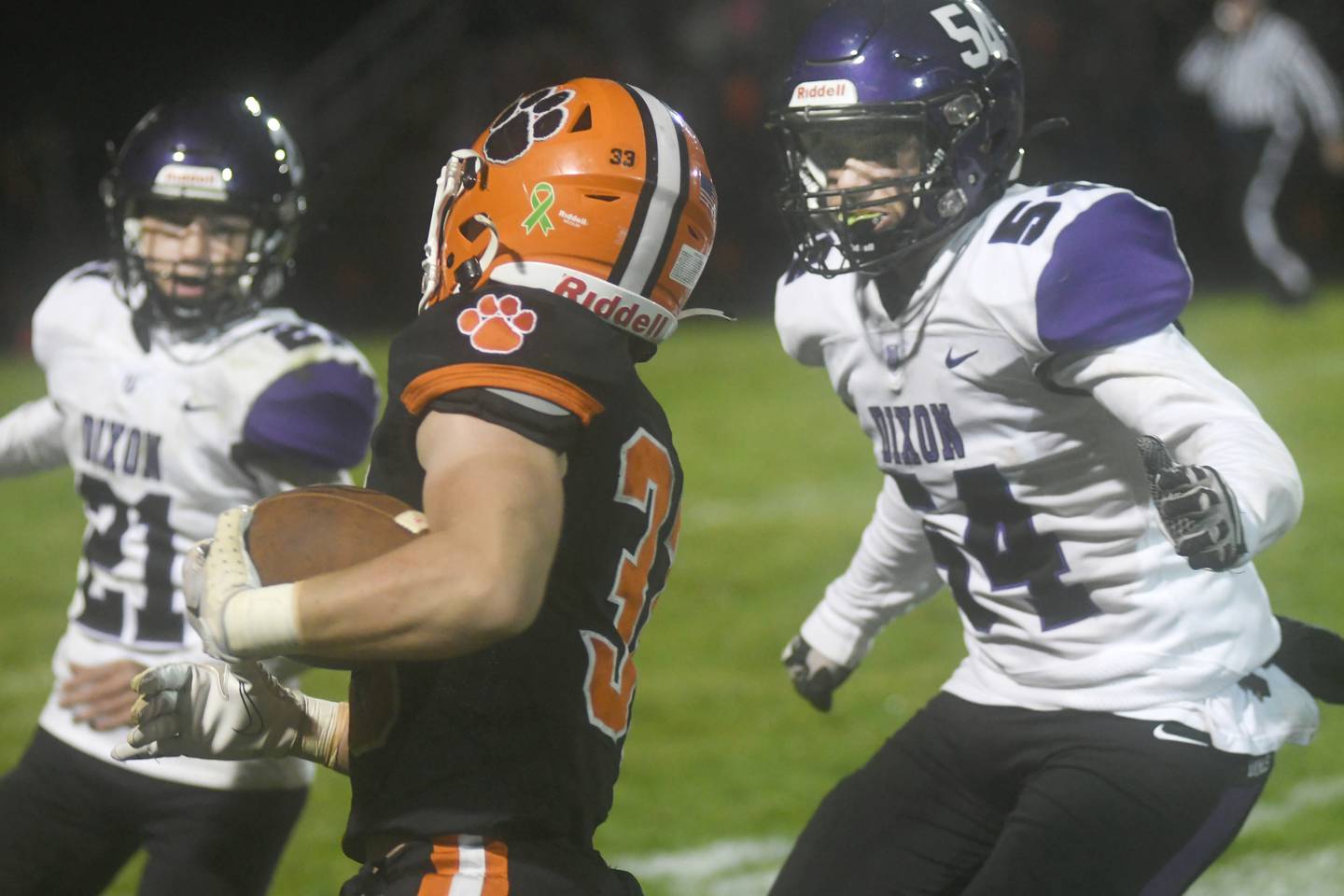 Dixon's Andrew Scheffler (54) and Tyson Dambman (21) look to stop Byron's Carsen Behn after a big gain during Friday, Oct. 14 action in Byron.Andrew