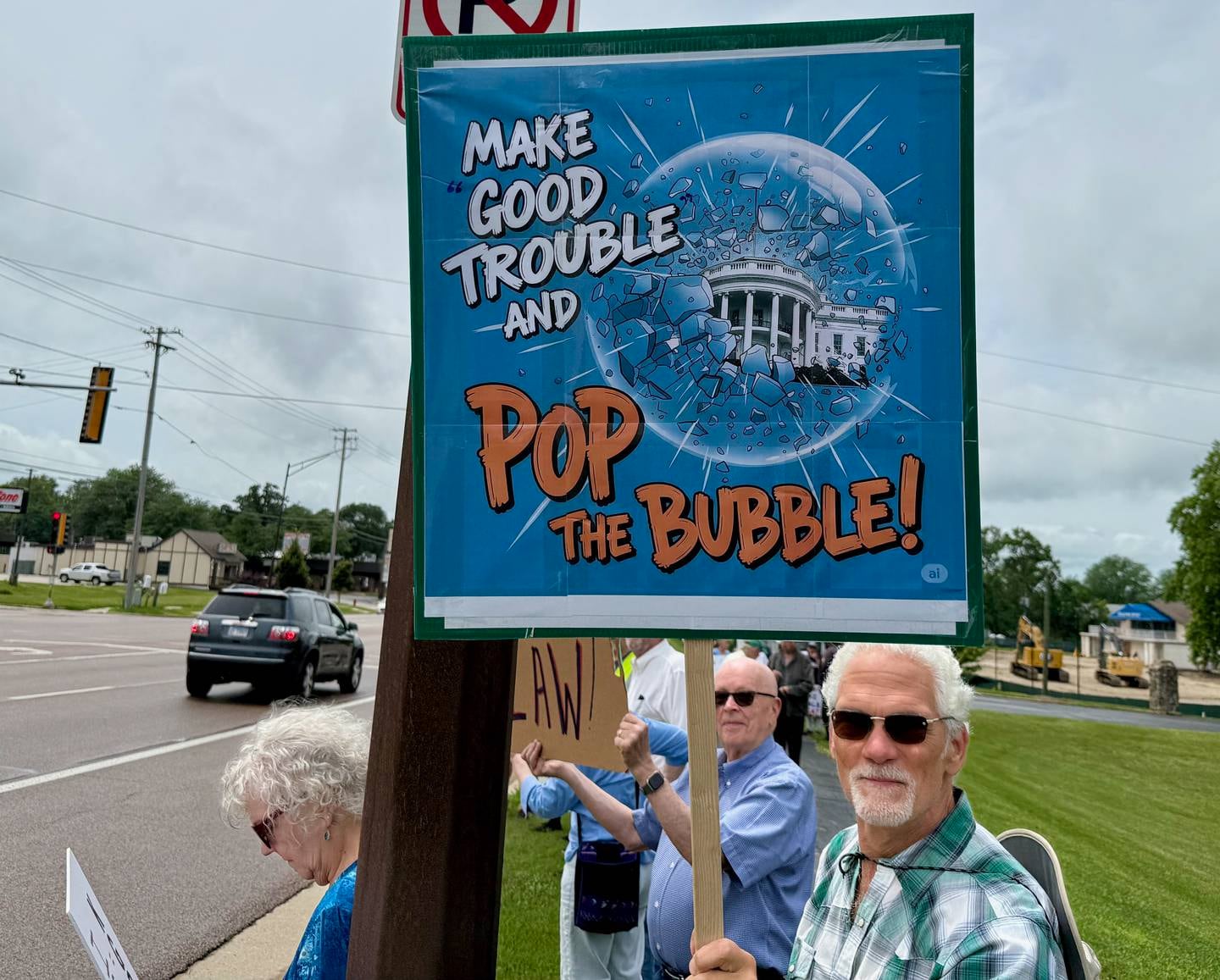 Protestors gather on Saturday, July 19, 2025, along Sycamore Road in Hopkins Park in DeKalb for a "Good Troubles Lives On" demonstration, one of thousands organized this week to honor the life and legacy of the late U.S. Rep. John Lewis. Though the official event was canceled due to weather Saturday, many still showed up to protest actions taken by President Donald Trump and his administration.