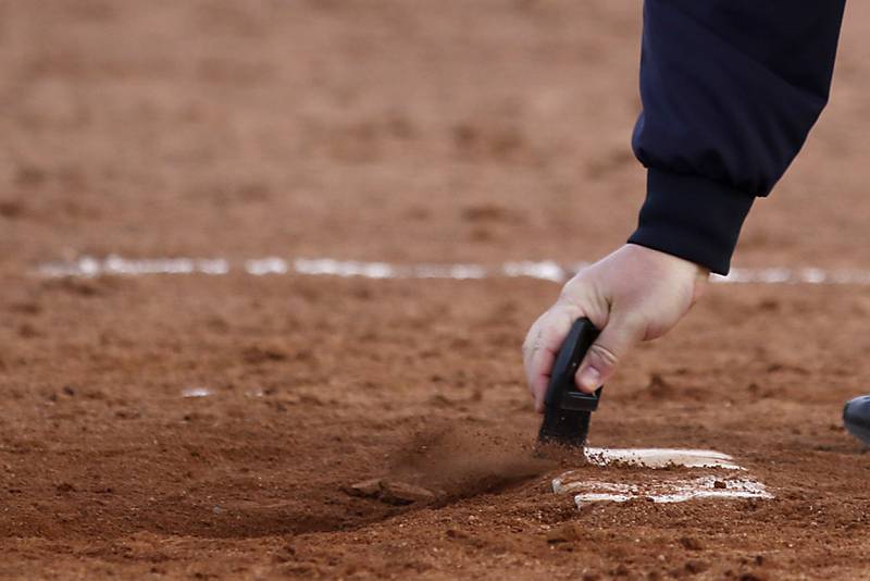 The pitching mound in=s cleaned off between innings during a nonconference softball Thursday. March 23, 2023, between Prairie Ridge and Grayslake North at Grayslake North High School.