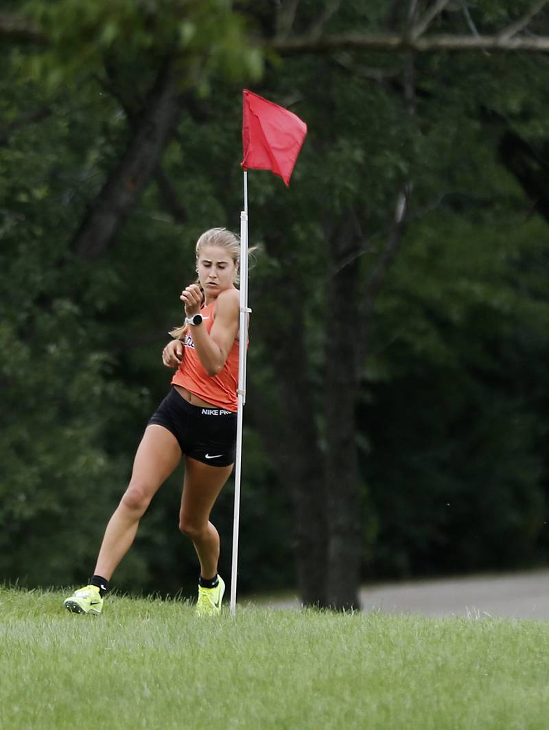 McHenry’s Danielle Jensen rounds a flag during the girls race of the McHenry County Cross Country Meet Saturday, August 27, 2022, at Emricson Park in Woodstock.