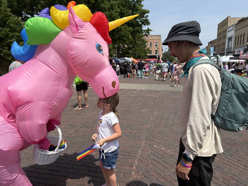 Harlow Steinburg, 6, of Woodstock, and Ryan Niven, right, speak to a unicorn during the Woodstock PrideFest June 15, 2025.