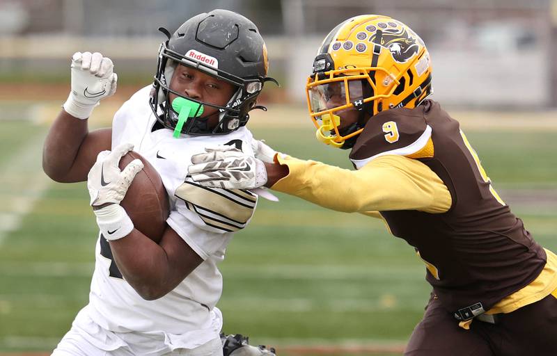 Sycamore's Tyler Curtis breaks the tackle of Carmel's Dev'ion Reynolds on his way to a touchdown during their Class 5A second round playoff game Saturday, Nov. 5, 2022, at Carmel Catholic High School in Mundelein.