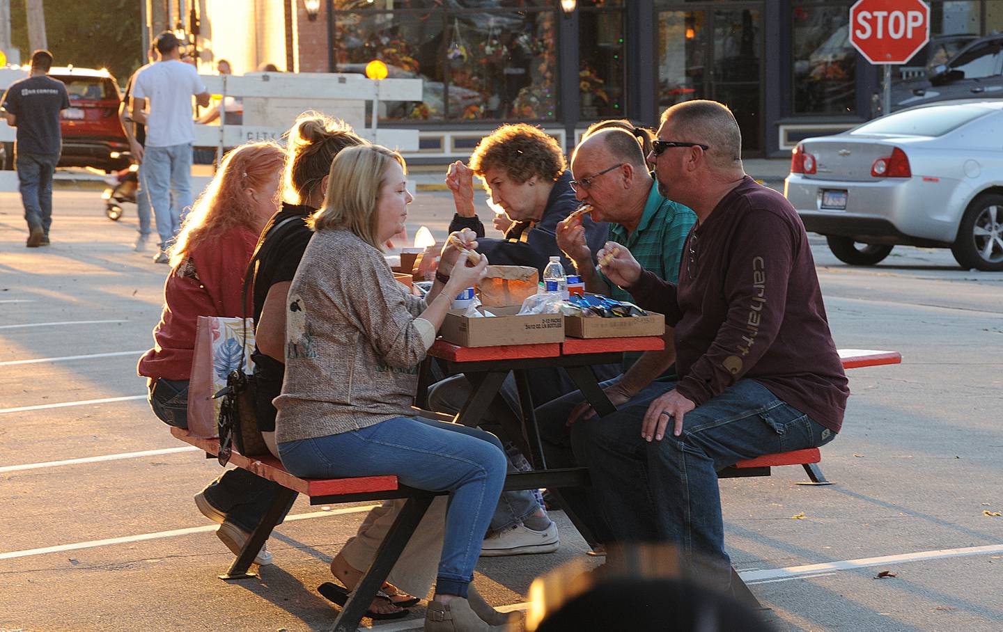 As the evening sun sets, a table full of patrons sample food during the Taste of Sandwich, Wednesday, Sept. 25, 2024, in downtown Sandwich.