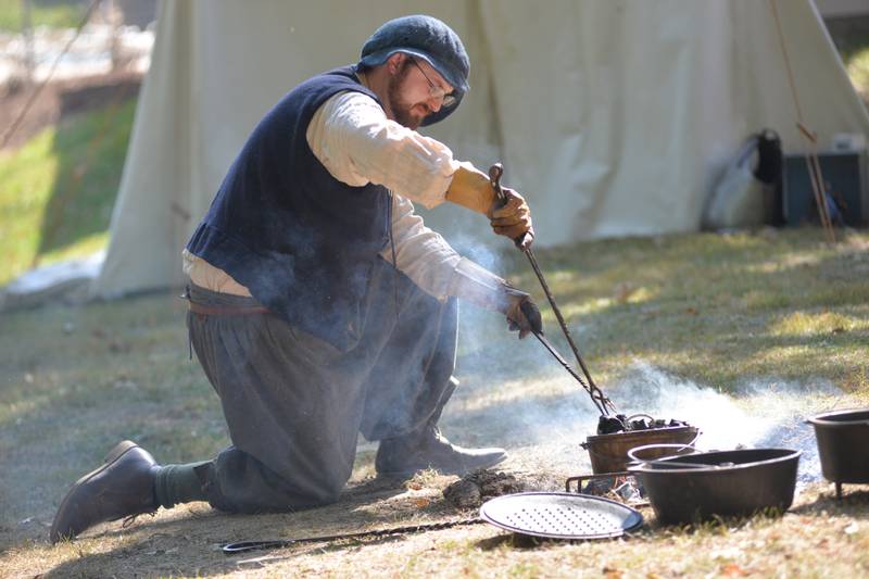 A participant tends to his fire at the Olde English Fair at Stronghold Camp & Retreat Center on Saturday, Oct. 5, 2024, during the Autumn on Parade festival in Oregon.
