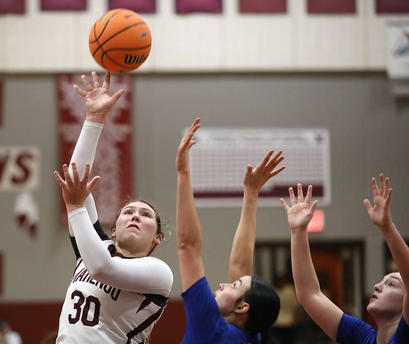Marengo's Macy Noe (left) shoots the ball over Genoa-Kingston's Zoe Boylen (center) and Regan Creadon (right) during an IHSA Class 2A Marengo Regional semifinal girls basketball game on Monday, Feb. 16, 2026, at Marengo High School.
