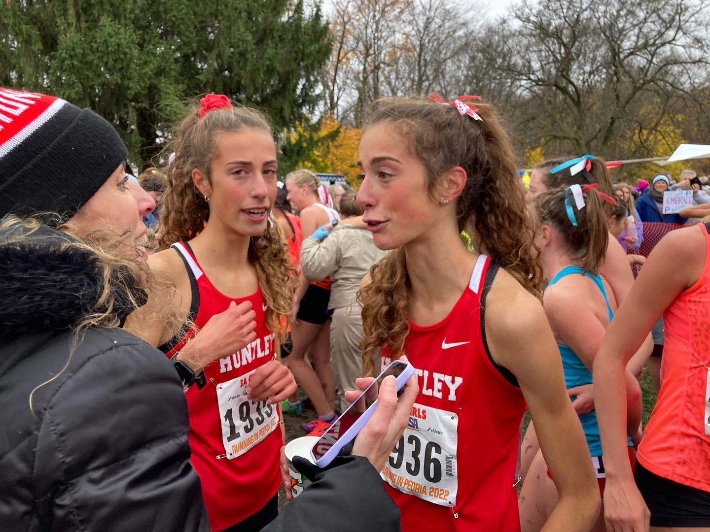 Huntley's Breanna Burak (1935) and Brittney Burak (1936) and their mother Sonia after their Class 3A race at the IHSA Cross Country State Meet.