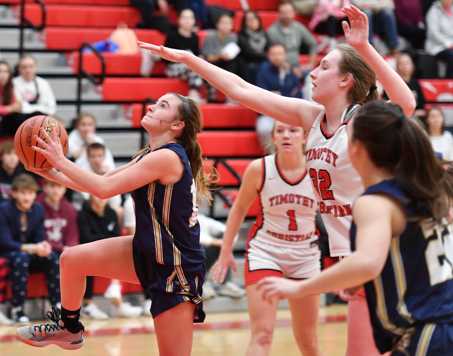 IC Catholic's Kelsey McDonough (left) goes in for a layup under the reach of  Timothy Christian's Grace Roland during the Class 2A Timothy Christian Regional championship game on Feb. 17, 2023 at Timothy Christian High School in Elmhurst.