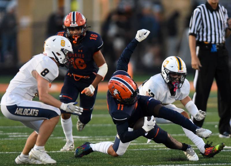 Joe Lewnard/jlewnard@dailyherald.com
Naperville North's Brock Pettaway, middle, gets tripped up between Neuqua Valley's William Beaman, left, and Zachary Schaefer during Friday’s game in Naperville.
