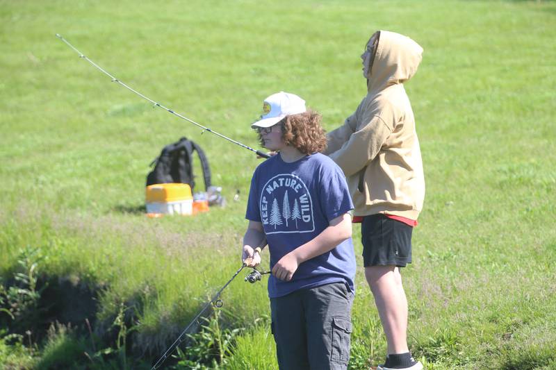 Teegan Dourghtery and Chris Chambers both of Peru, fish along the shore of Baker Lake during the 24th annual Kids Fishing Expo on Saturday, May 11, 2024 n Peru.