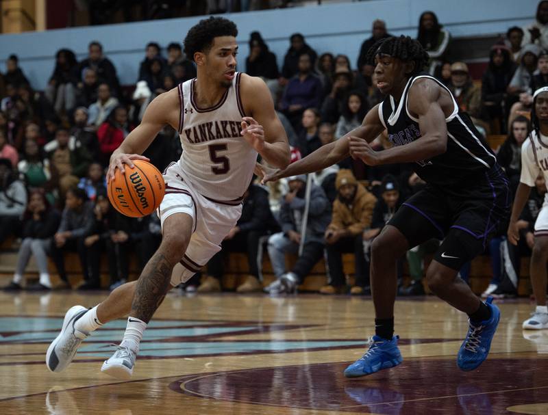 Kankakee's EJ Hazelett, left, makes a drive toward the net as Thorton's Deandre Higgs, right, guards in a game on Friday, December 12, 2025.