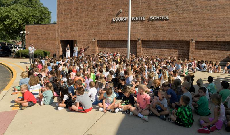 Principal Mike Wall welcomes students at Louise White Elementary School in Batavia gather outside befor the traditional ringing of the school bell on Wednesday, Aug 14, 2025.