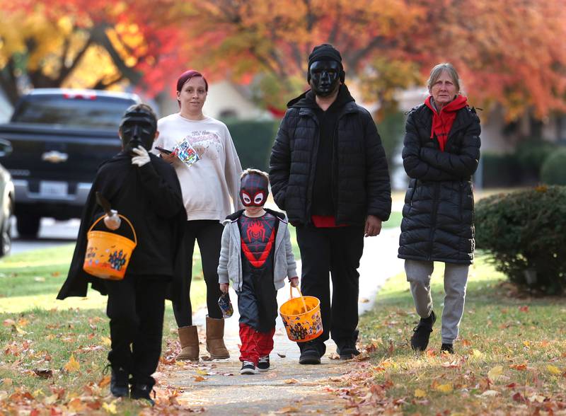 Trick-or-treaters head down the sidewalk on Halloween, Friday, Oct. 31, 2025, in DeKalb.